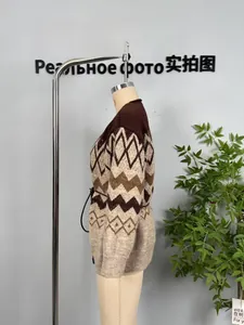 Detail showing vintage argyle knit pattern and ribbed cuff of the brown cardigan