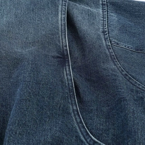 Dettaglio del tessuto denim blu scuro con cuciture a doppio ago di alta precisione
