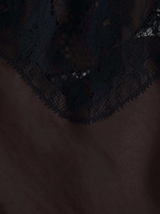 Détail du tissu satiné marron foncé avec dentelle florale noire complexe sur le décolleté en V