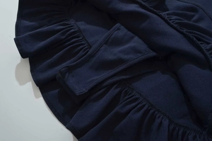 Detail of navy cotton dress featuring ruffled hem and integrated safety lining