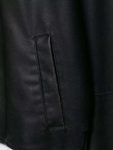 Detail of premium black faux leather jacket showing stitching and side pocket texture
