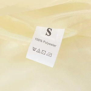 Detail view of the 100% polyester fabric texture and size S care label for winter jacket