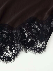Gros plan sur l'ourlet en dentelle de cils noire d'une robe en satin marron foncé