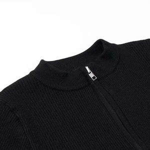 Detail of black ribbed knit jumpsuit with silver zipper and mock neck collar design
