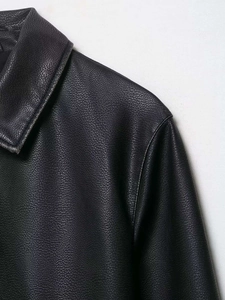 Detailed close-up showing the fine grain texture and glossy finish of the black faux leather