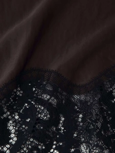 Vue détaillée du tissu en satin noir avec une bordure en dentelle délicate sur la robe