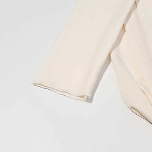 Nahaufnahme der beigen Kleidmanschette mit hochwertigem, strukturiertem Strickgewebe