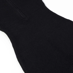 Detail of black ribbed knit jumpsuit showing waist tailoring and vertical texture