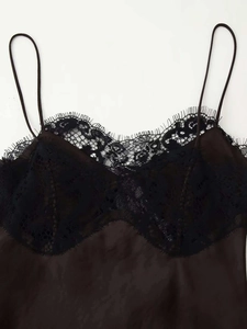 Détail de la dentelle noire sur la robe en satin marron avec de fines bretelles fines