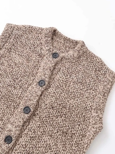Close-up of warm brown marl knit vest with round neck and dark round buttons