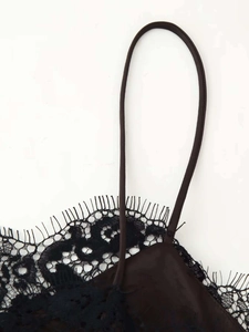 Détail de dentelle de cils noire élégante et de tissu satiné brillant sur la robe