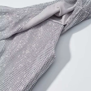 Detail von silbernem Paillettenstoff am schulterfreien Oberteil mit Glitzersteinen