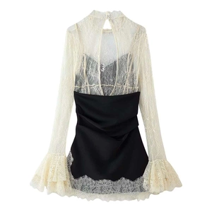 Elegante weiße Spitzenbluse mit ausgestellten Ärmeln und schwarzes Patchwork-Kleid