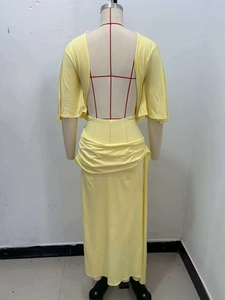 Detail view of backless pale yellow long dress with elegant cross strap design