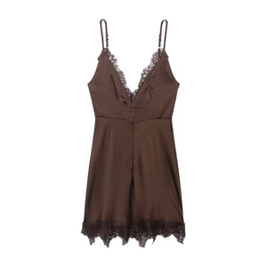 Dettaglio dell'abito sottoveste in raso marrone con bordo in pizzo nero delicato