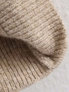 Close-up of camel knit texture with thick ribbed weave and brushed warm material