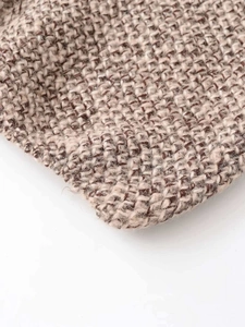 Detailed macro view of the warm brown multi-color knit texture and weaving pattern