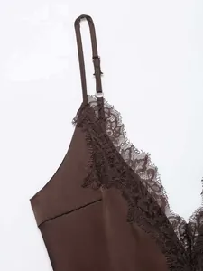Dettaglio di canotta in raso marrone con bordo in pizzo ciglia e spalline regolabili