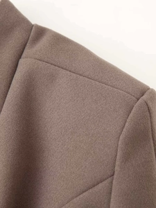 Detailed macro shot of coffee brown wool blend coat shoulder stitching and fabric texture