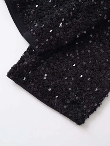 Dettaglio ravvicinato di paillettes nere su tessuto con cuciture di alta qualità su giacca