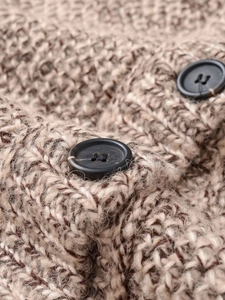 Macro detail of mixed brown chunky knit fabric with two matte black round buttons