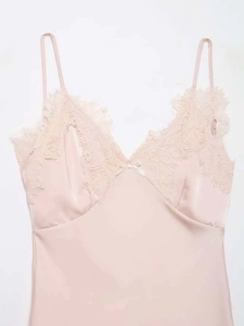 Détail d'une nuisette en satin rose pâle avec dentelle de cils délicate et nœud en soie