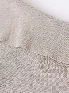 Close-up macro view showing the fine knit texture and soft beige fabric of the sweater