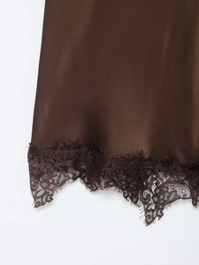 Dettaglio del tessuto di raso marrone caffè con bordo in pizzo ciglia decorativo