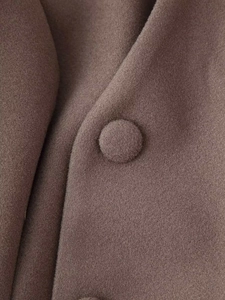 Close-up of brown wool coat fabric featuring texture and matching fabric-covered button