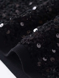 Dettaglio ravvicinato di ricamo con paillettes nere su giacca fashion con scollo a giro