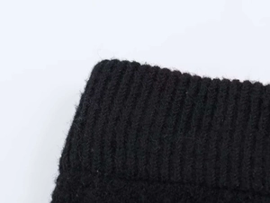 Gros plan détaillé de la texture en maille côtelée noire sur l'ensemble de Noël
