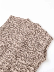 Close-up of chunky mixed brown knit fabric showing ribbed neckline and texture details