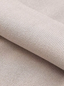 Close-up of beige ribbed knit fabric showing the soft texture and fine stitching detail