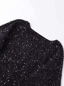 Dettaglio macro di paillettes nere luccicanti e bordo in maglia della giacca trendy