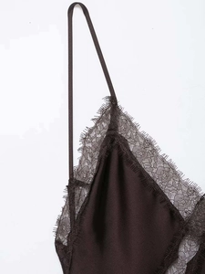 Détail de la dentelle délicate sur l'encolure en V d'une robe en satin soyeux