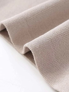 Detailed macro view of soft light khaki ribbed knit fabric for autumn fashion knitwear