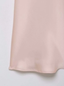 Détail de l'ourlet de la robe en satin rose avec couture fine et tissu soyeux