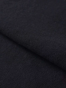Dettaglio del tessuto in maglia nera ad alta densità con texture uniforme e raffinata