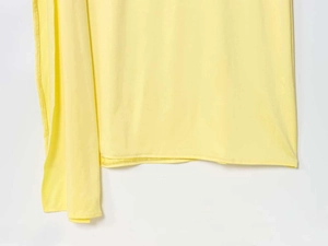 Detail view of pale yellow knit dress showing high-quality stitching and fabric texture