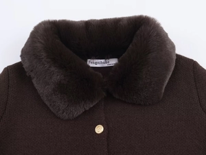 Detail showing the brown faux fur collar and golden embossed button on knit cardigan
