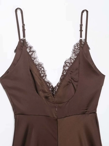 Dettaglio dello scollo a V con pizzo nero su un abito sottoveste in raso marrone