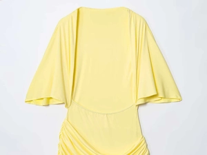 Detail of the elegant light yellow dress with ruched waist and batwing sleeves detail