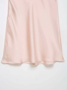 Gros plan détaillé du tissu satiné rose clair avec des finitions de couture de qualité