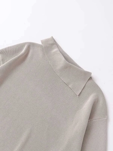 Close-up of soft knit sweater collar with oatmeal texture and rolled edge detail