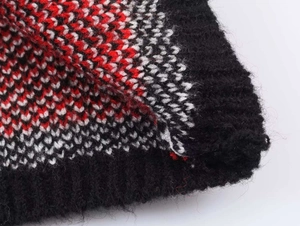 Detailopname van winterse kerstgebreide jacquardstof met zwarte geribbelde randafwerking