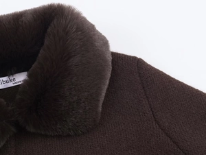 Close-up of deep brown knit cardigan featuring a plush faux fur collar and inner label
