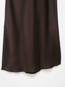 Détail de la robe midi en satin marron foncé montrant le tissu lisse et l'ourlet