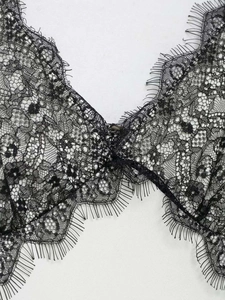 Détail de l'encolure en dentelle florale avec bordure en cils sur robe noire