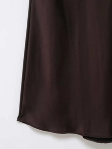 Détail de la robe midi en satin marron chocolat montrant l'ourlet lisse et la dentelle