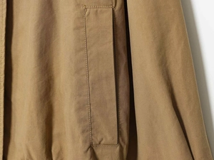 Detailed macro view of khaki pilot jacket twill fabric texture and stitched side pocket